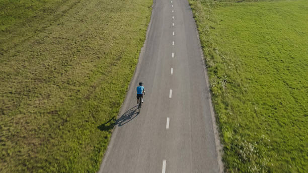 istock cyclist riding on an empty flat asphalt road 2159855775