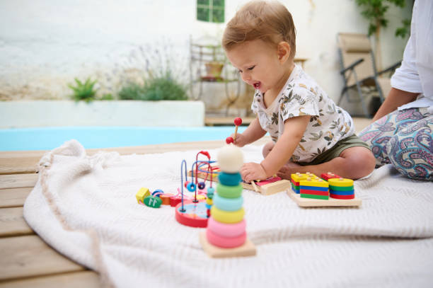 istock Toddler playing with educational toys outdoors on sunny day 2159856864