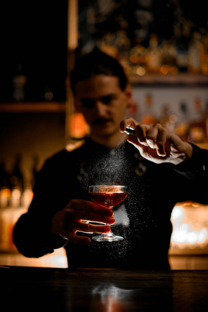 istock Artful Spray. Bartender adds final touches, spraying cocktail from bottle. 2159858051