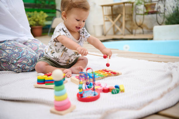 istock Happy baby playing with toys outdoors by the poolside 2159859495