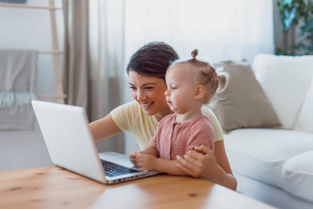 istock Mom and child seated on floor together using laptop. 2159860705