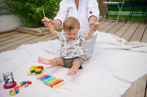 istock Happy toddler playing with toys outdoors guided by parent 2159860764