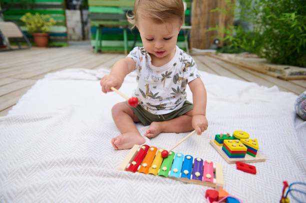 istock Toddler playing with colorful xylophone outdoors on a sunny day 2159860827