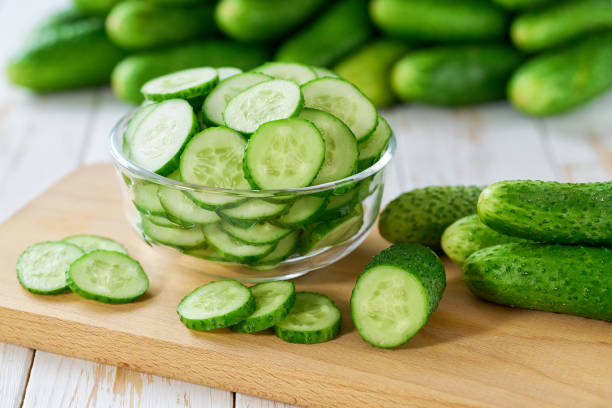 istock chopped cucumbers slices in a clear glass bowl on a wooden table, selective focus. 2159862349