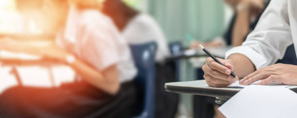 istock Exam at school with student's taking educational admission test in class, thinking hard, writing answer in university classroom, education and world literacy day concept 2159868189