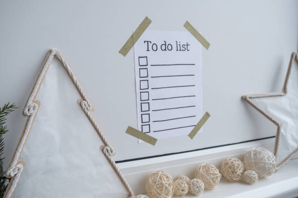 istock TO DO LIST checklist text on paper note stick on while wall with cozy minimalistic handmade Christmas decor. New year aims resolutions. Low key festive Planning and setting goals 2159886107