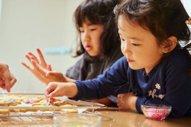 Sisters enjoying decorating cookies at home