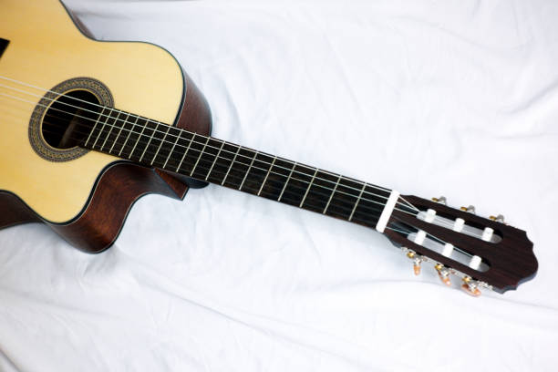 istock close up classical guitar headstock and neck with brown wood pattern on a grey background. 2159895117