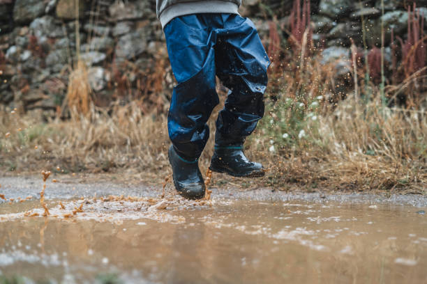 istock A child is jumping in the rain, splashing water everywhere 2159898510