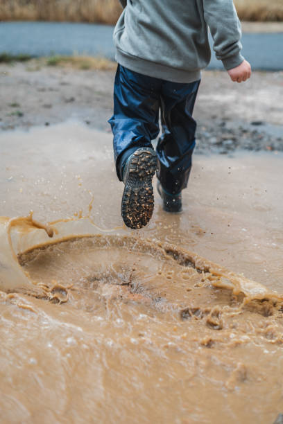 istock A person is running through a muddy puddle 2159898646