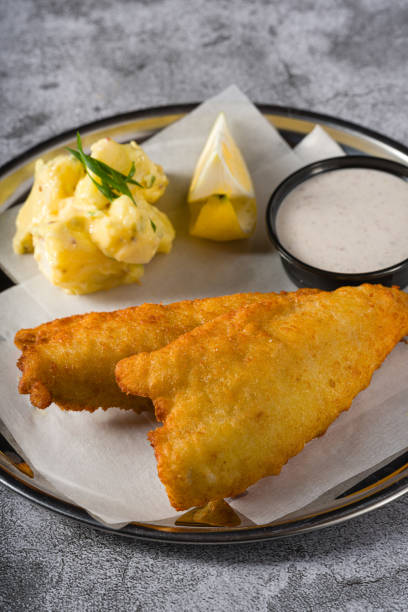 istock Deep fried coated fish fillet with potato salad on stone table 2159899839