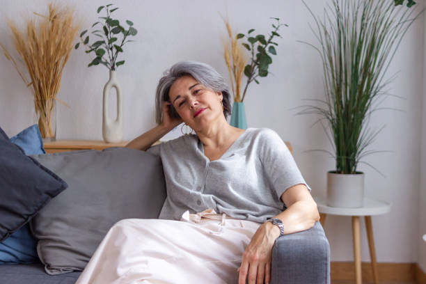 istock Mature woman relaxing on comfortable sofa at home 2159901838
