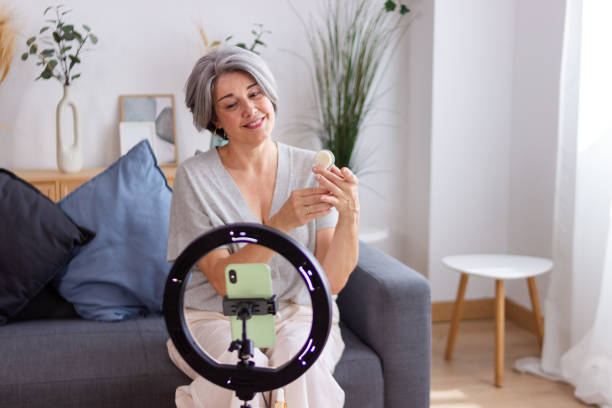 istock Influencer filming video using ring light on tripod for her beauty blog 2159901956