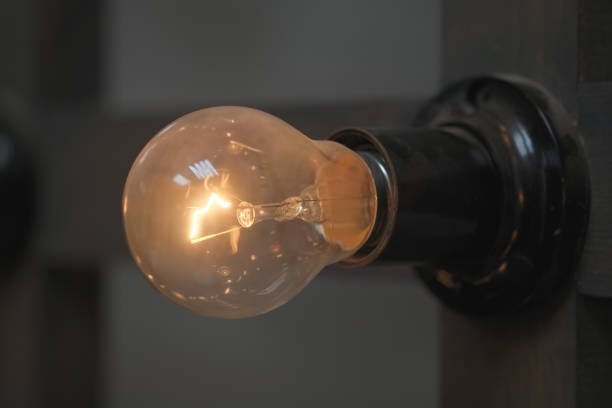 Old edison lamp mounted on wooden background