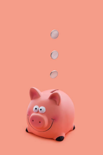 istock Pink piggy bank with coins falling down 2159904753