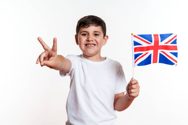 Child running with UK flag. British supporter. Little Britain fan kid celebrating victory. Children watching UK national team play. Championship game. Go Britain!