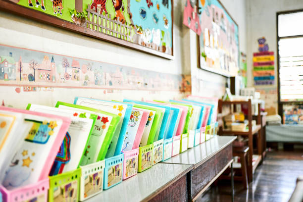 Children books arranged in boxes over cabinet in primary school classroom