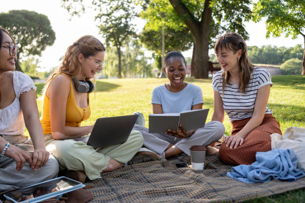 istock A group of multiracial female university students have fun in a campus park while studying together 2159914359