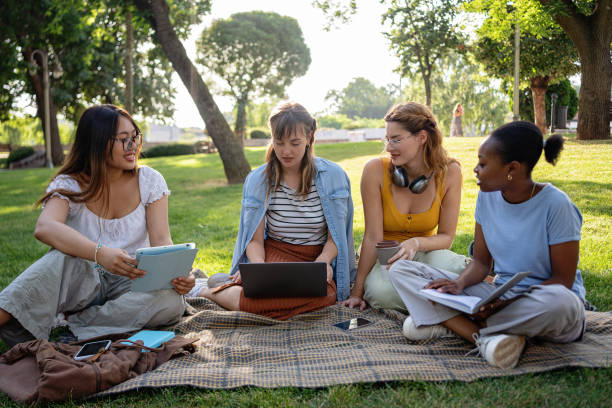 istock Multiracial female university students studying together in a public park 2159914369