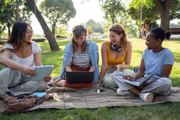 istock Multiracial female university students spend sunny day outdoors while studying together 2159914379