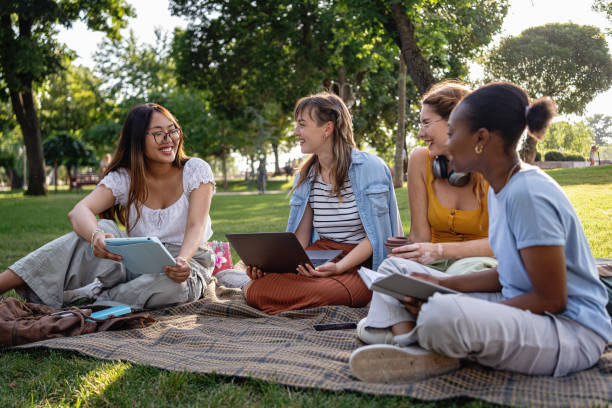 istock Multiracial female university students spend sunny day outdoors while studying together 2159914382
