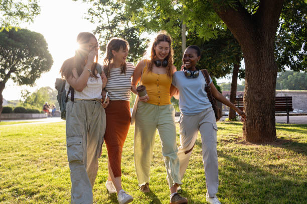 istock Multiracial female university students walking together through the campus park 2159914447