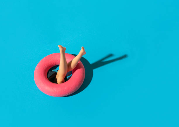 A girl jumps into the water through a swim ring, summer holidays activities
