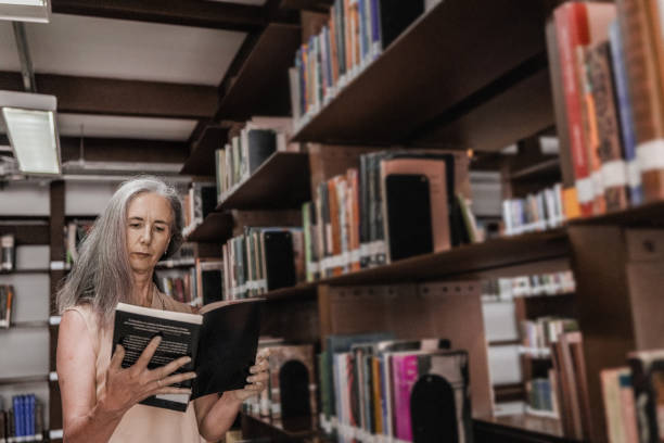 Mature woman reading a book at library