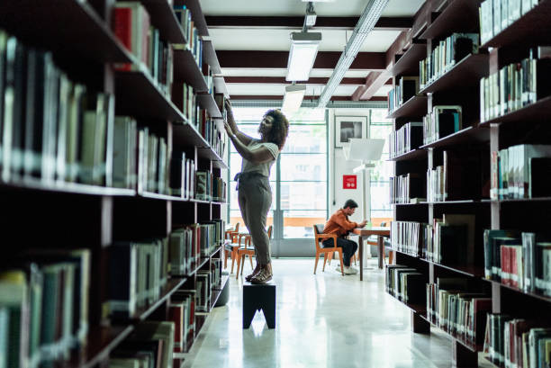 Female university student browsing books in library