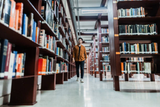 istock Mid adult man walking at library 2159922455