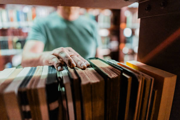 istock Close-up of man catching a book at library 2159922509