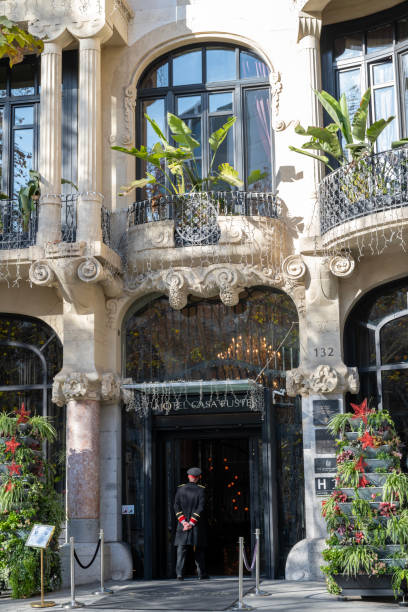 Barcelona, Spain - January 1, 2024. A doorman standing at the entrance of historic Hotel Casa Fuster in Barcelona, Spain