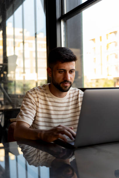 istock Young university student using a laptop in a cafe. 2159926211