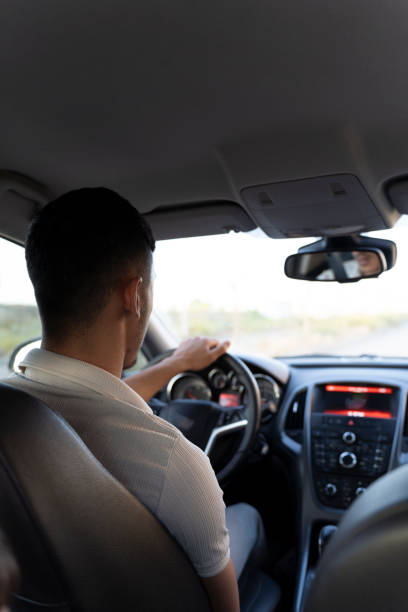 Young man driving a car.