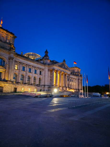 The Reichstag, a historic legislative government building on Platz der Republik in Berlin, is the seat of the German Bundestag. From 1995 to 1999, the Reichstag was fundamentally redesigned by Norman Foster for its permanent use as a parliament building. The image shows the Reichstag building at dusk during spring season.