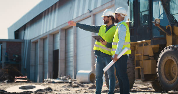 Engineer, construction and team talking with tablet outdoor for building inspection or maintenance. People with tech pointing for engineering, architecture and project management or safety planning