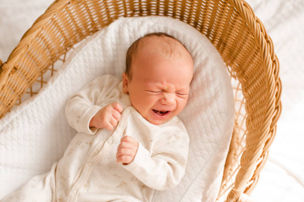 istock Baby boy lying crying in bed sleeping 2159933835