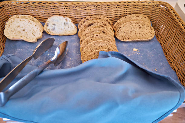 istock Sliced rye and wheat bread in wicker baskets on a banquette. Self-service restaurant. Selective focus 2159934820