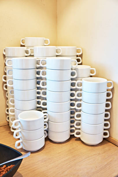 A beautiful white set of cups on a banquet table.