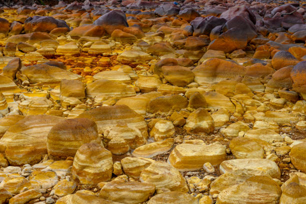 The warm, orange mineral deposits of Rio Tinto sculpt a textured landscape with reflective puddles