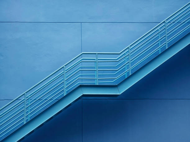 istock A set of stairs ascending a large blue wall 2159936616