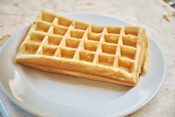 Freshly baked waffles on a white plate.