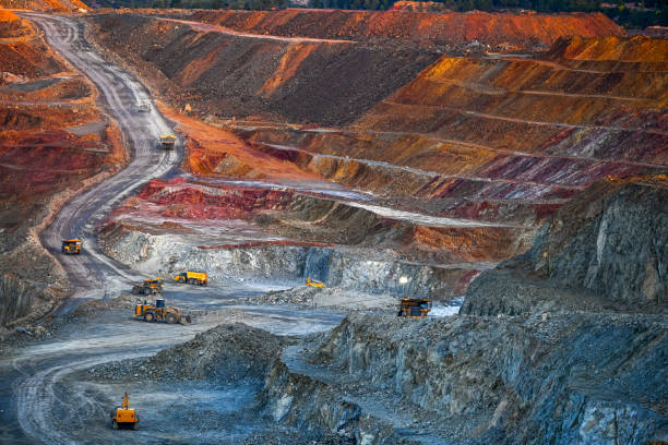 istock Dusk Over Multicolored Open Pit Mine with Equipment 2159942426