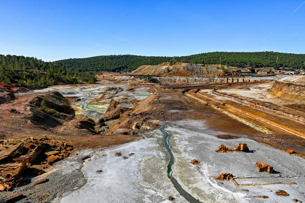 A wide-angle shot of the Rio Tinto mines, with its distinctive orange and white mineral deposits and a winding stream