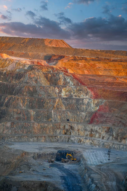 istock Dusk Over Multicolored Open Pit Mine with Equipment 2159942462