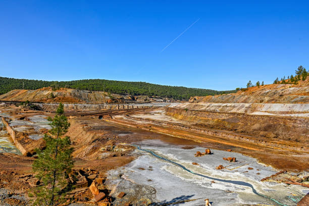A wide-angle shot of the Rio Tinto mines, with its distinctive orange and white mineral deposits and a winding stream