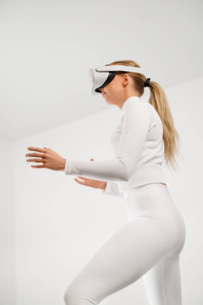 istock Woman in White Using Virtual Reality Headset in Bright White Room 2159942968