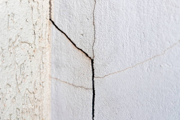 istock Crack in the wall. Cracks can be caused by soil movement, inadequate structural load, climate variations, natural wear and tear and even construction errors 2159945659