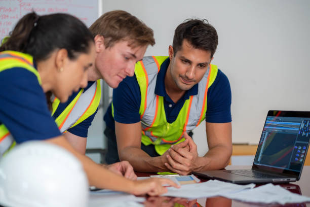 istock A group of engineers engages in a discussion around digitization displays to ensure that the robotic arm can operate smoothly, with input from a blue-collar worker to meet customer needs based on quality control standards. 2159946409