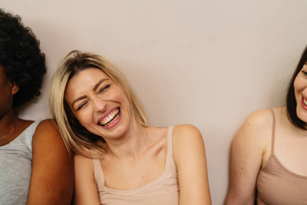 Portrait of a couple of a diverse young women, isolated on a white background, showing love and affection towards each other